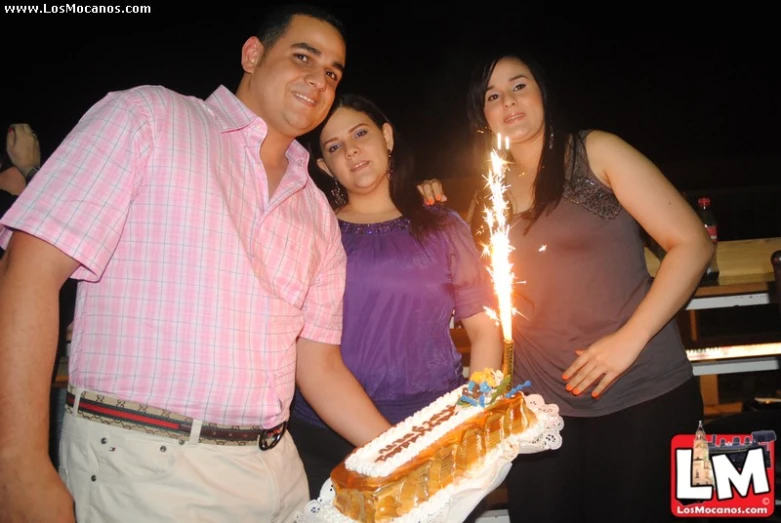 a woman holding a sparkler next to two men and a girl