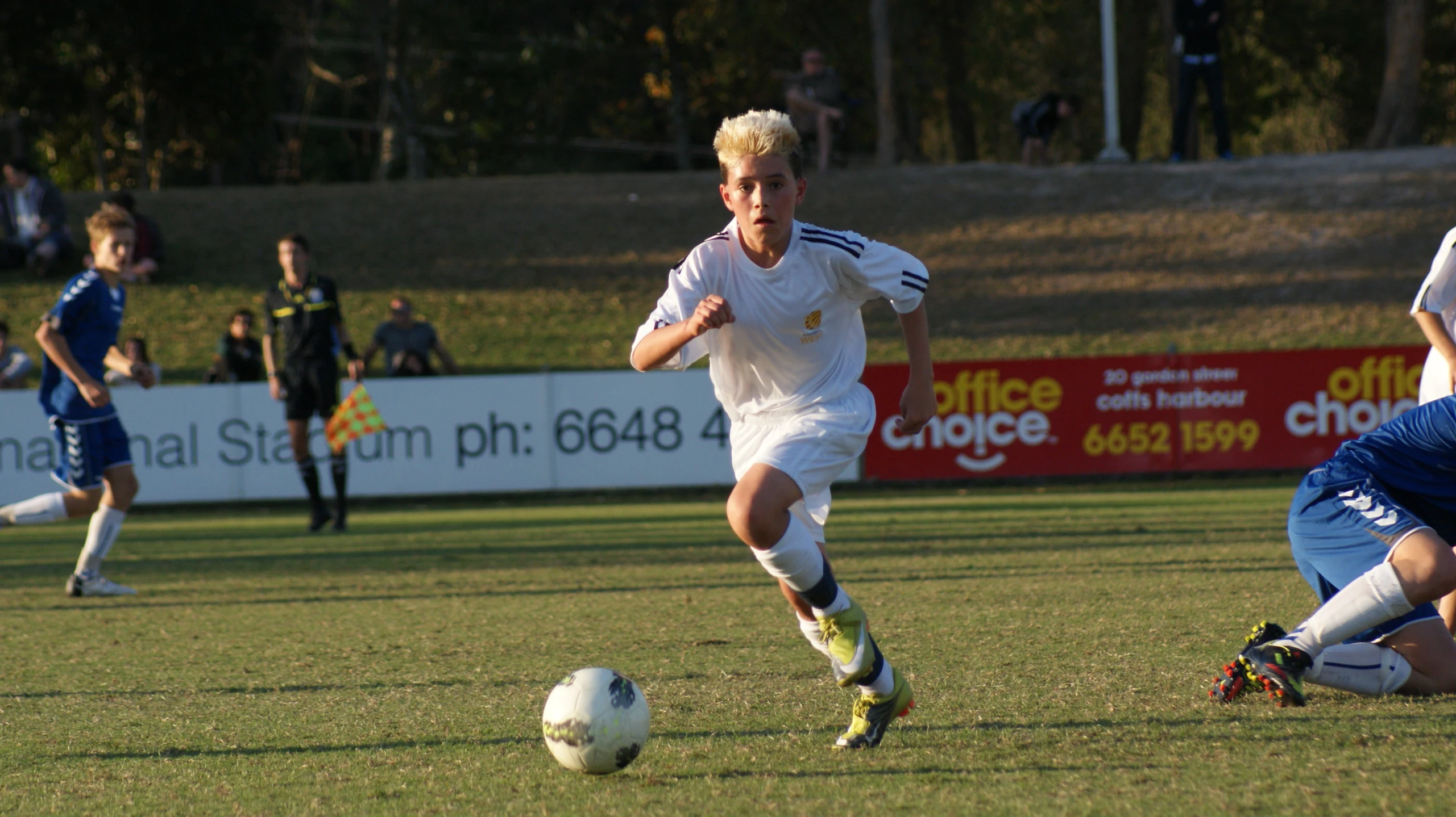 two guys kicking a soccer ball on a soccer field