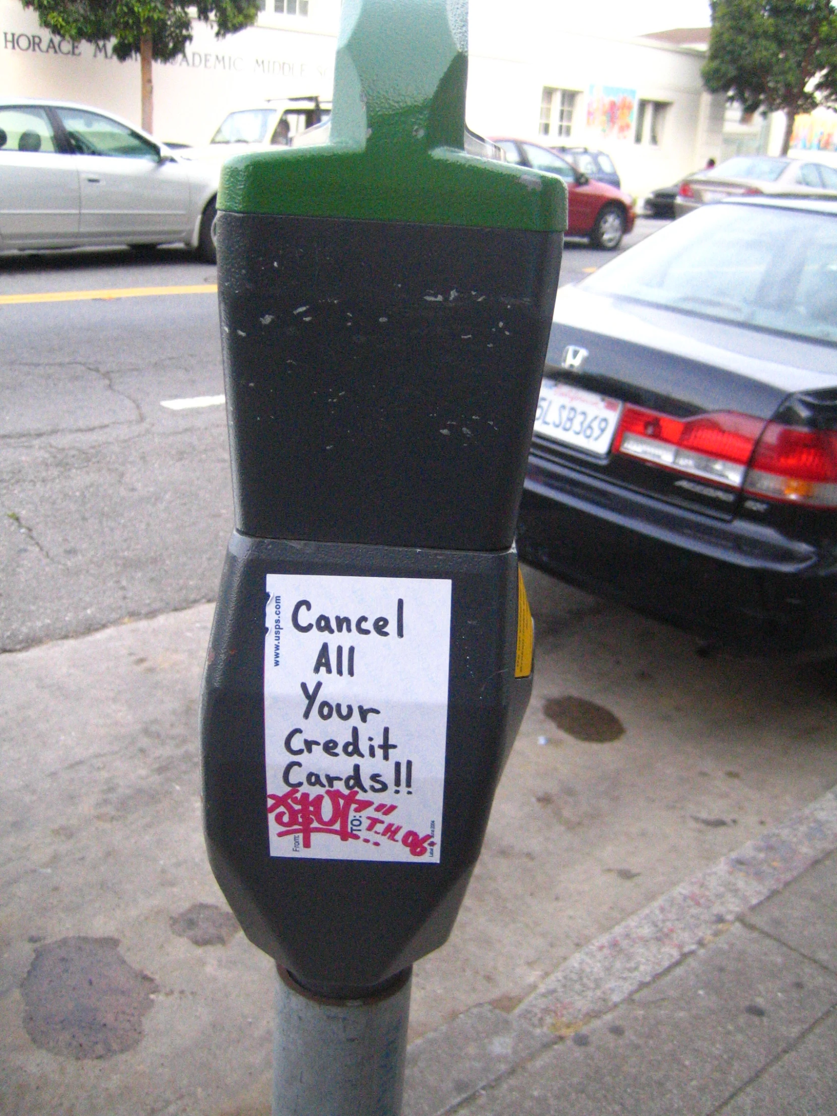 a parking meter on the sidewalk with graffiti on it