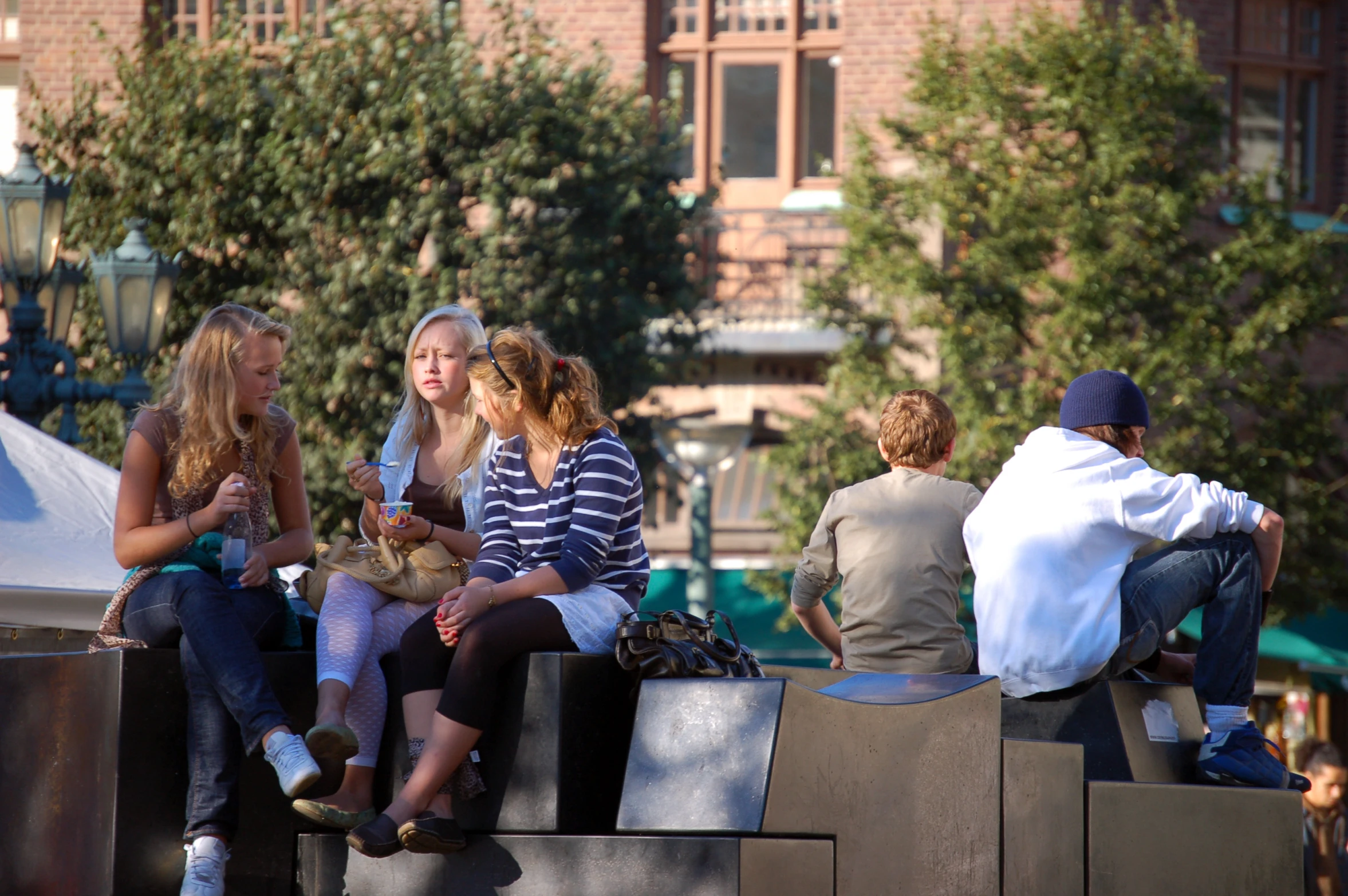 a group of women are sitting together outside