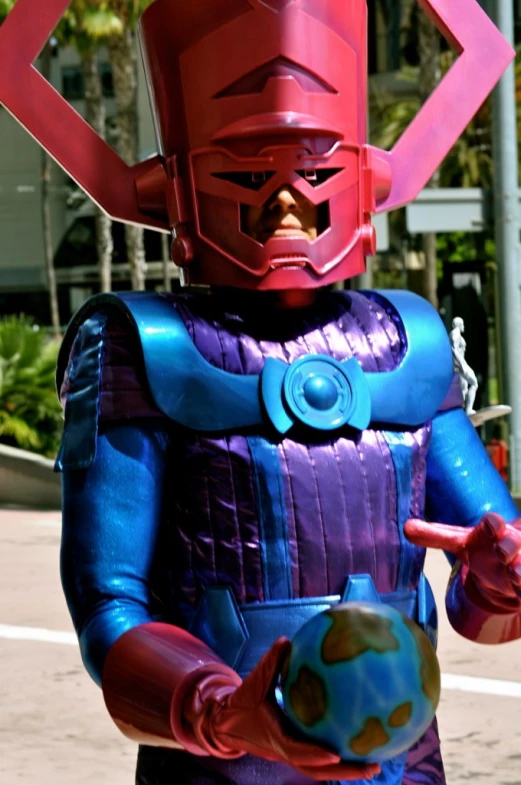 man dressed in purple and blue uniform holding a green ball