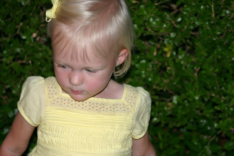 a young blonde girl with a bow in her hair