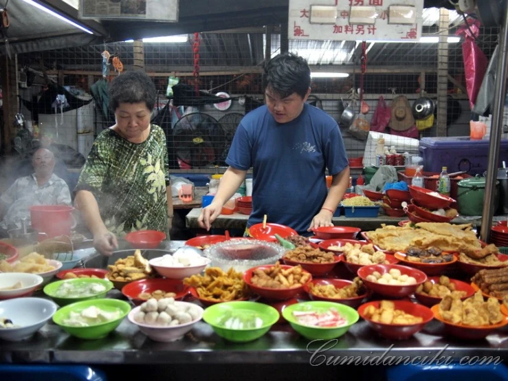 man and woman preparing food at outdoor market