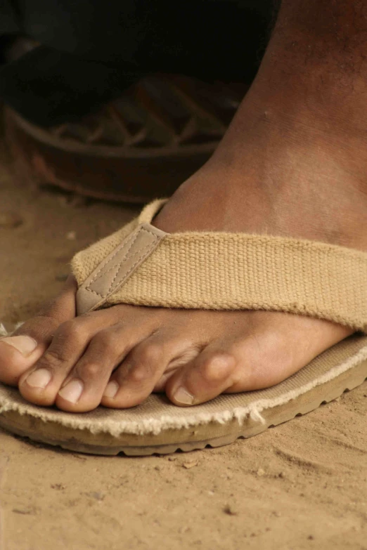a close up of a persons bare foot wearing sandals