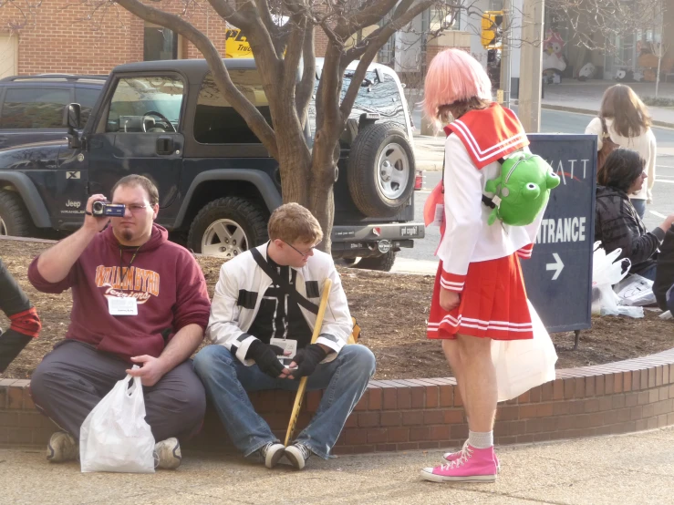 a couple of people sitting by a curb