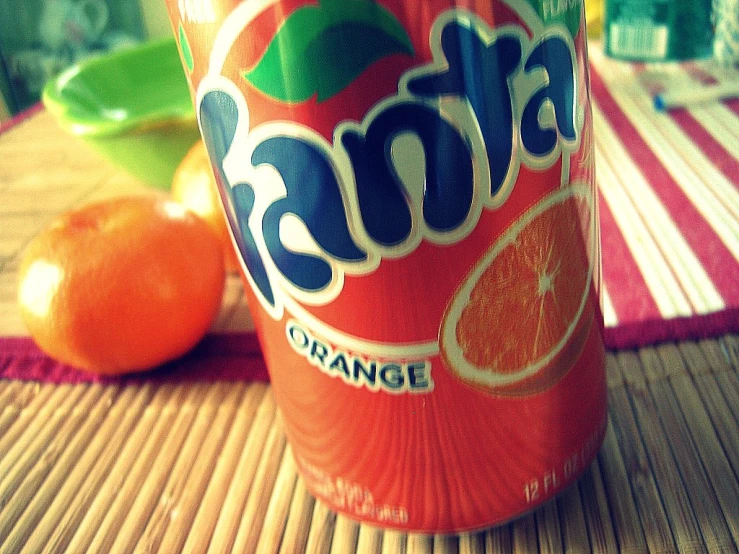 a can of orange soda sitting on top of a table
