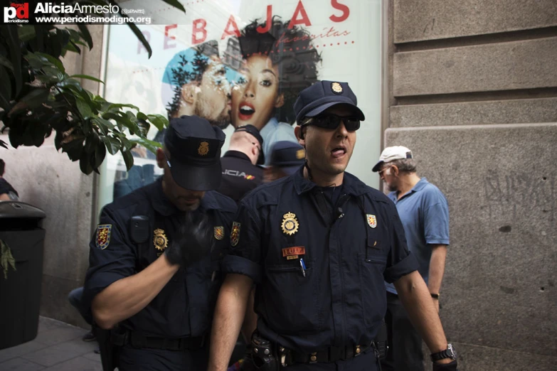 two police officers standing in front of a movie poster