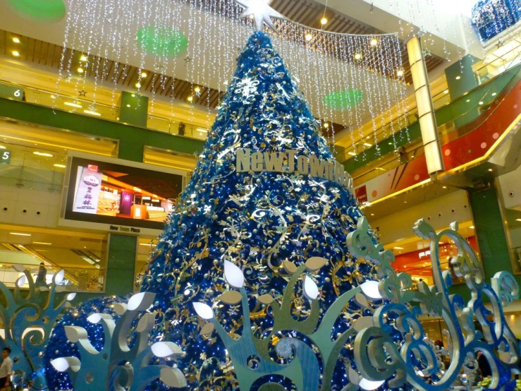 a christmas tree is in the center of a shopping mall