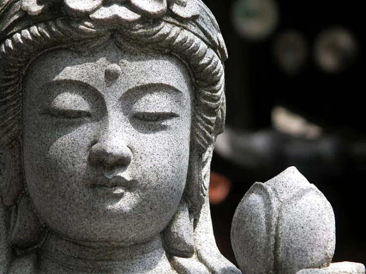 closeup of statue with lotus shaped head on display