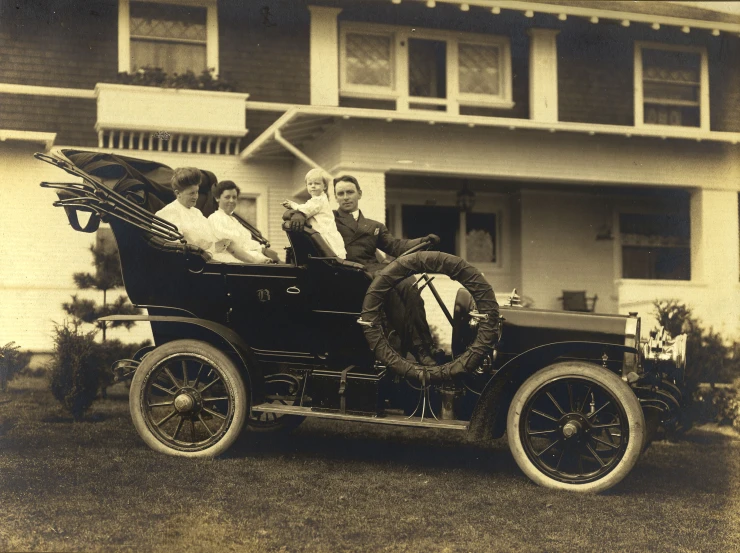 vintage po of a man and woman driving an old car