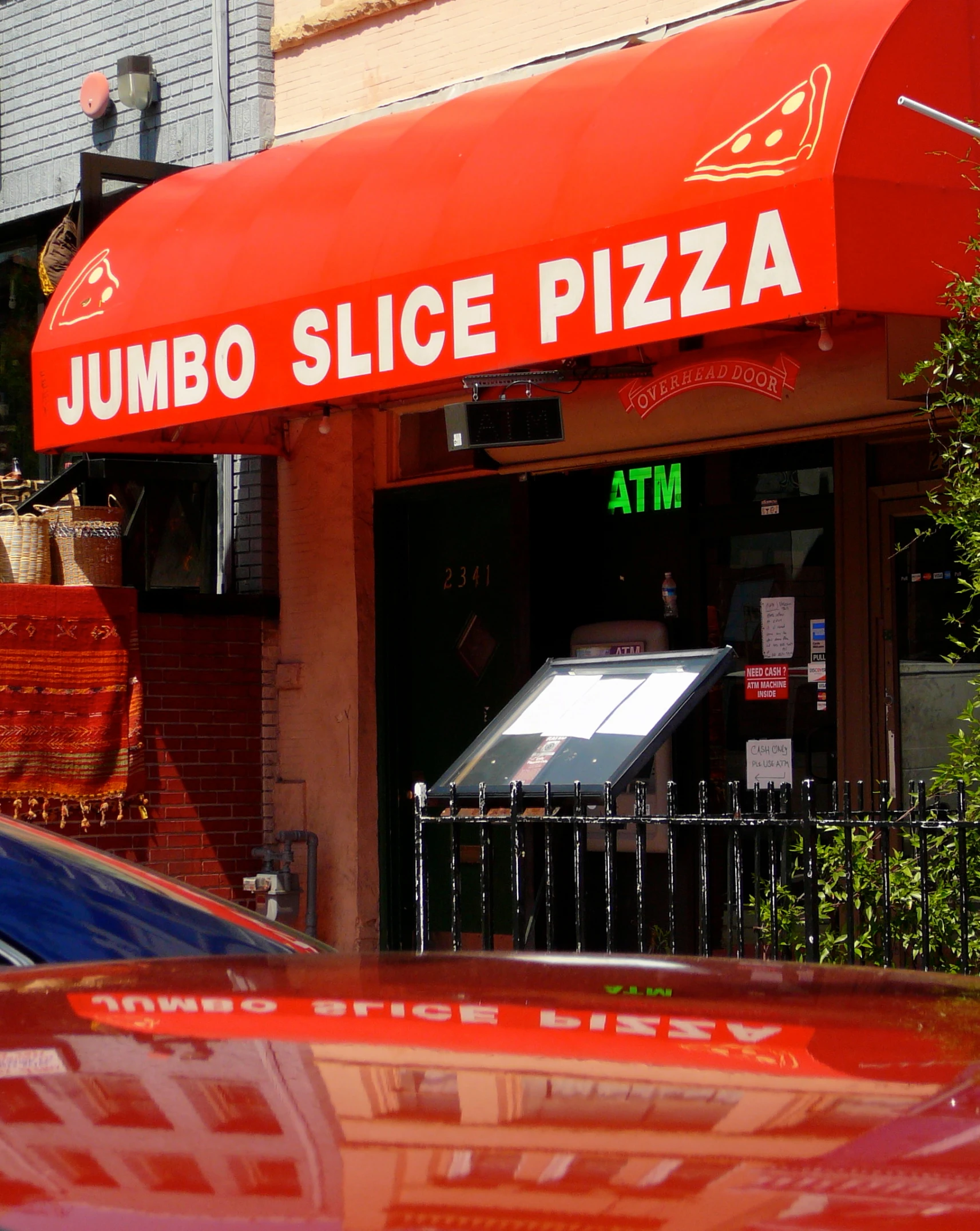 a street cafe with a red awning on a street corner