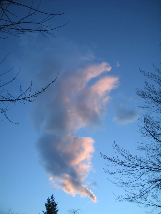 a white cloud in the sky with some black and white clouds