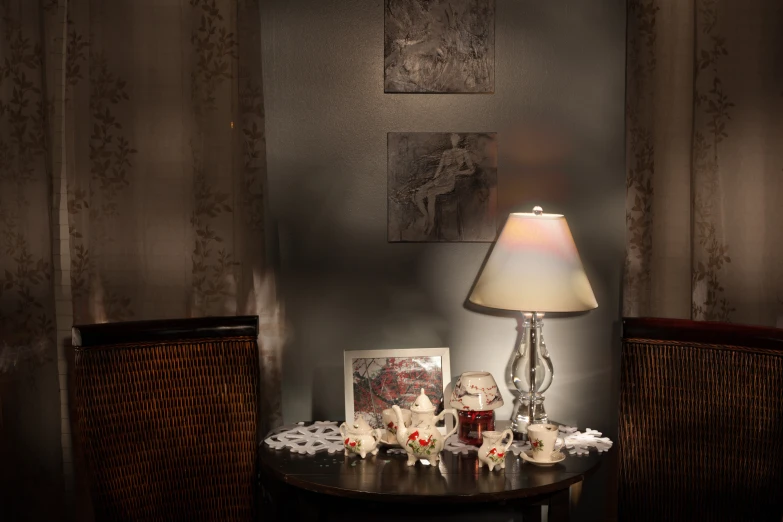 a lamp, flowers and candles sit on a table with decor