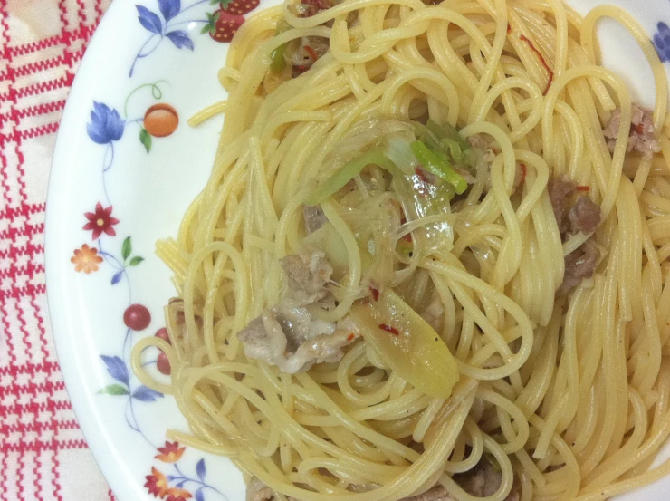 a plate of spaghetti with meat and vegetables