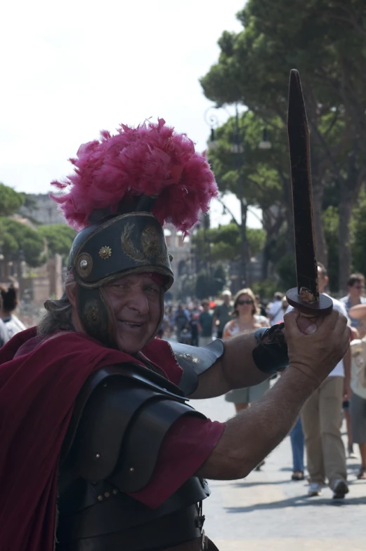 an old man wearing a roman gladia costume holding a sword