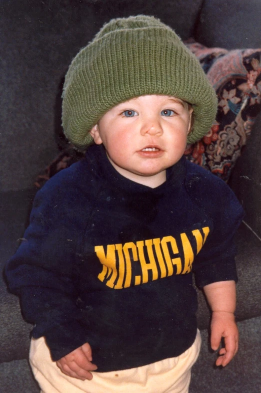  in sweatshirt wearing hat standing near sofa