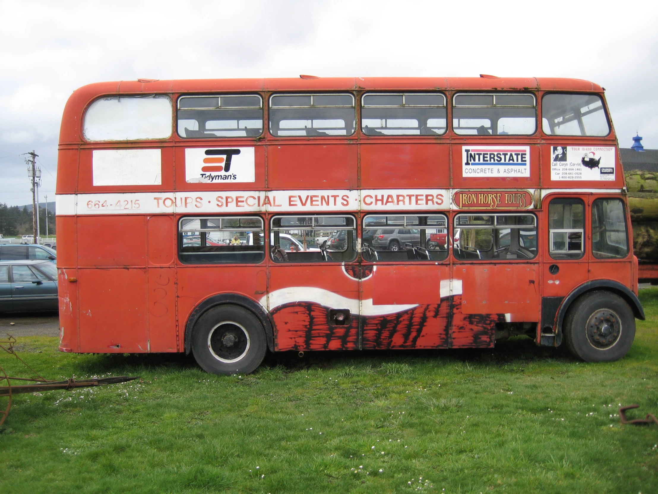 an orange double decker bus on some grass