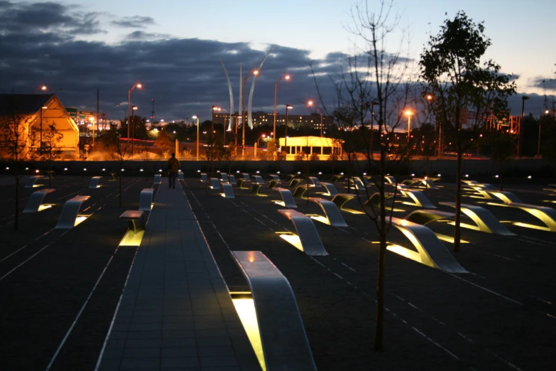 an array of benches near buildings under lights