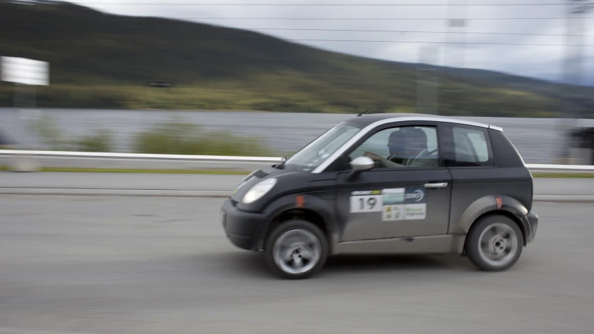 a small electric car driving down the road