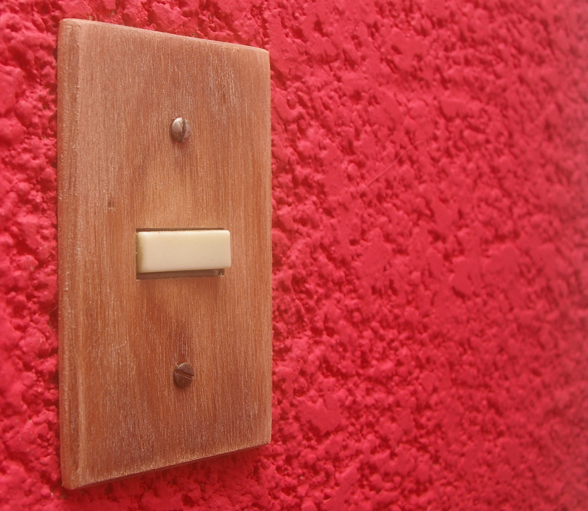 a piece of wood mounted on a red wall