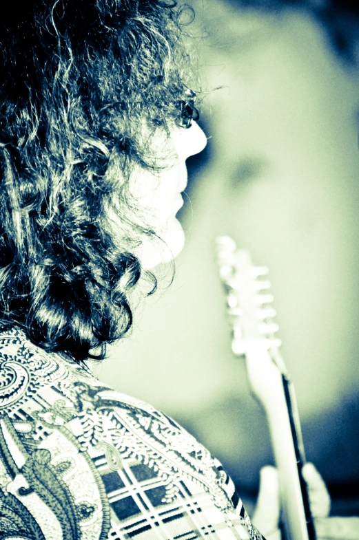 a woman holding an electric tooth brush on her left shoulder