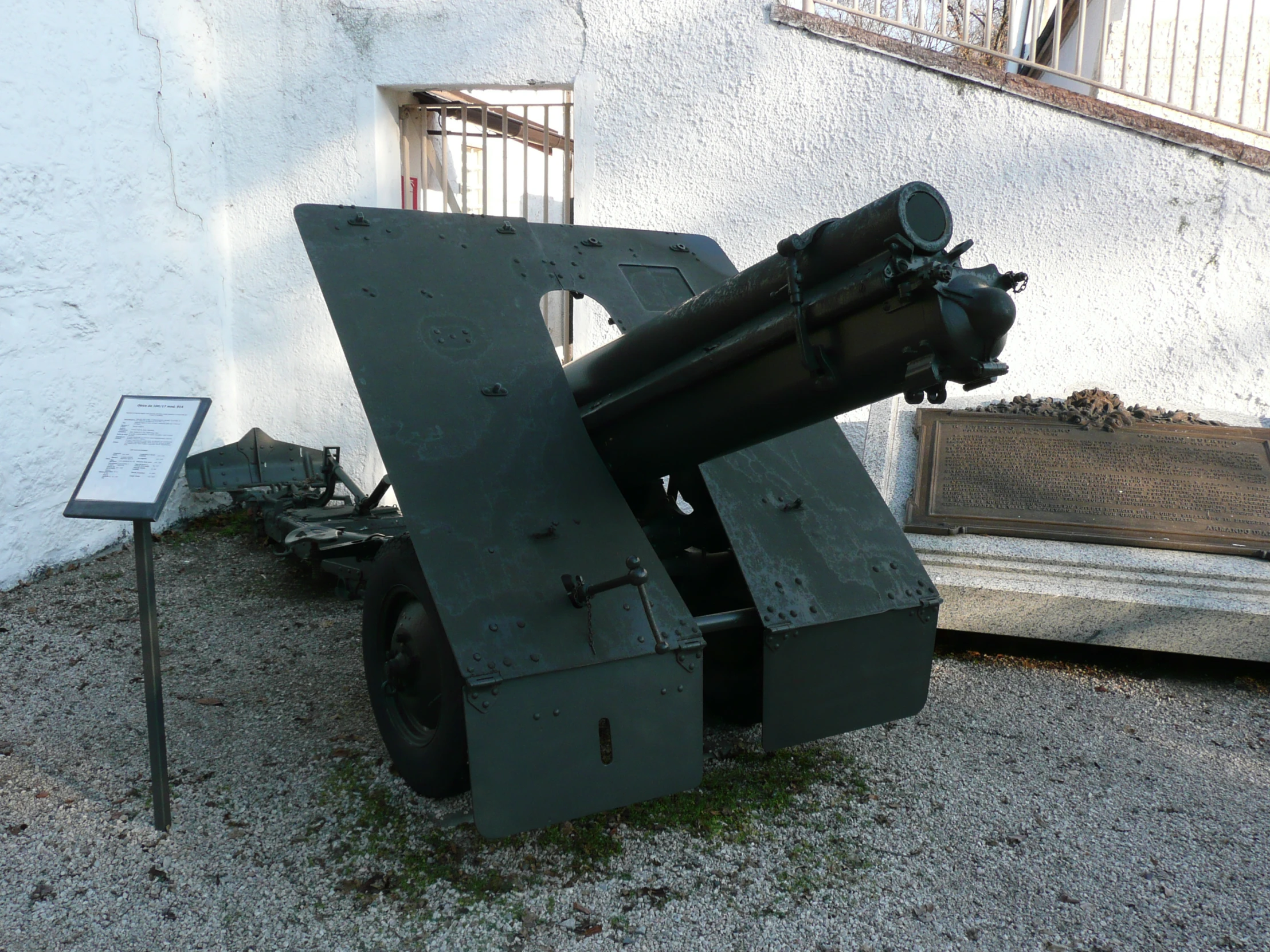 a large gun sits outside of a building