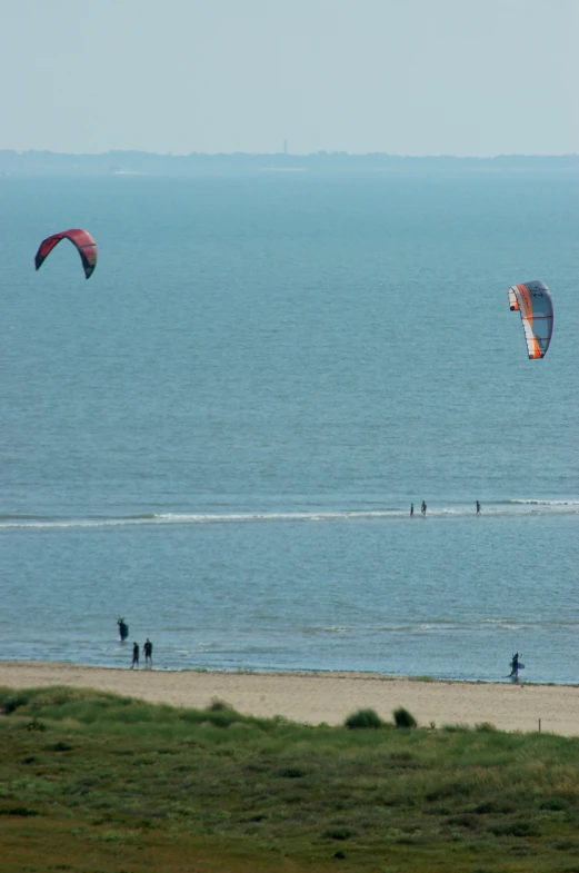 some people at the beach and one is para sailing