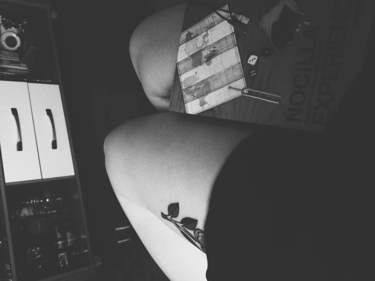 a woman's thigh in the shape of her panties with a small box containing a book about pography