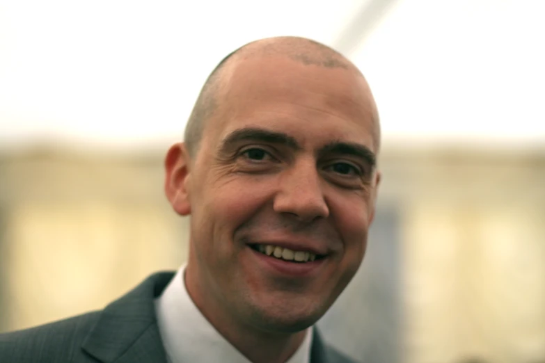 man smiling with a grey suit and tie