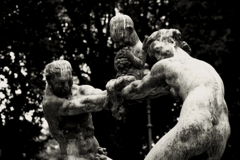 two stone sculptures of two men boxing in a park