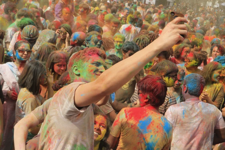 group of people celeting with colored powder on their faces