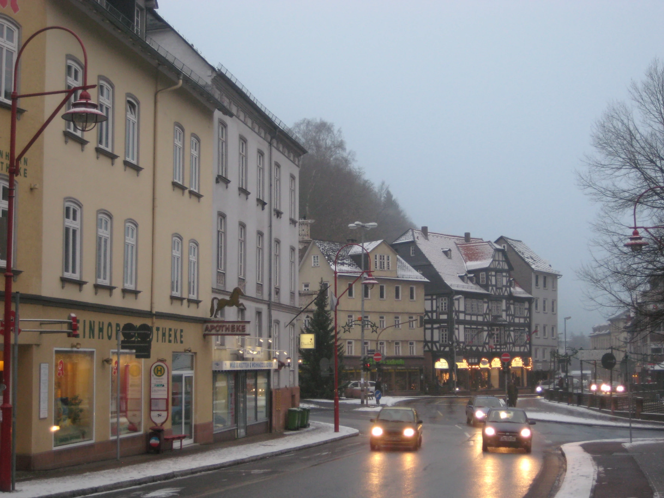 a few cars driving down the street in front of some buildings