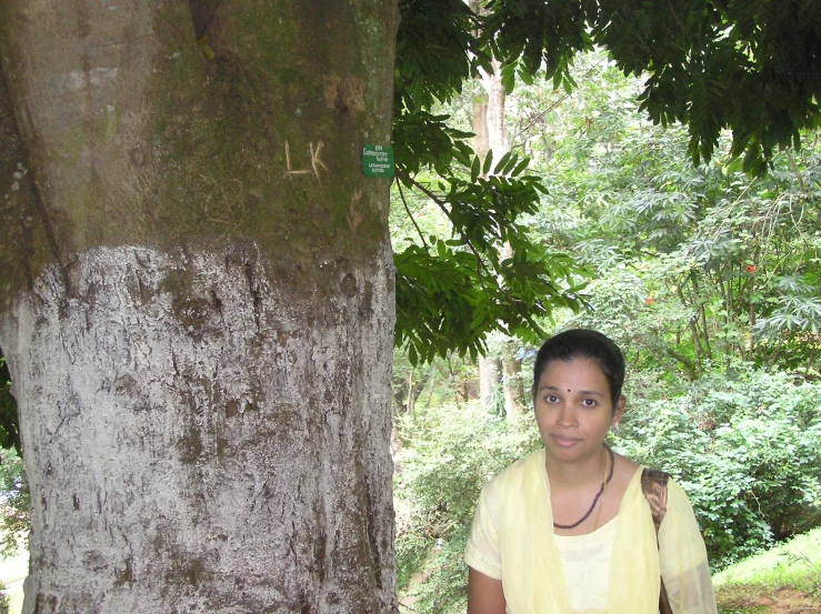a woman posing for a po by a tree