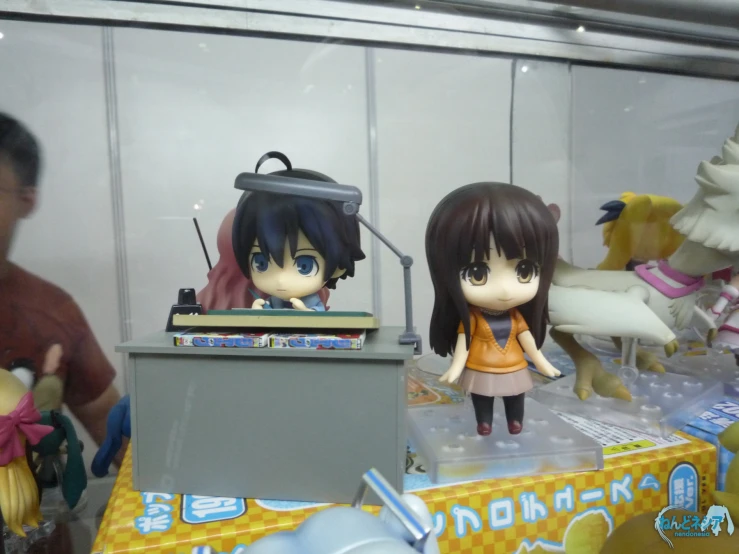 two figurines of girls in an office setting