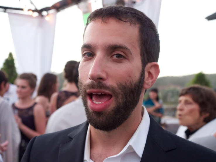 a man with a surprised face at a social gathering