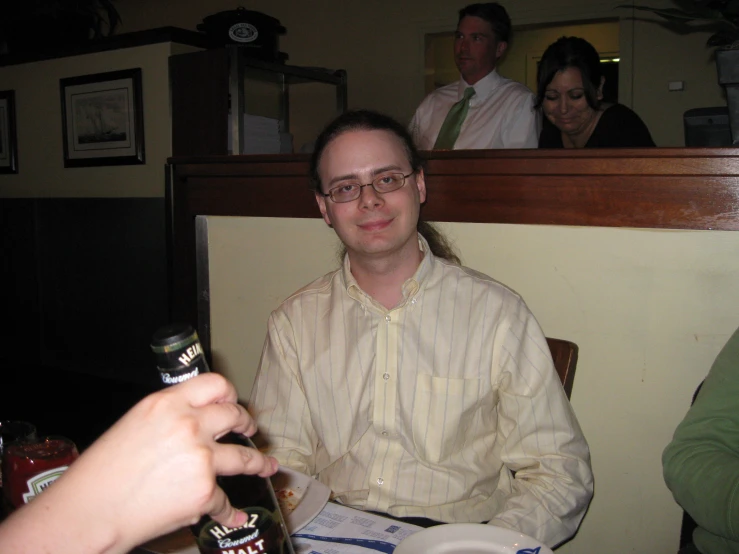 a man sitting next to a woman while holding a bottle of beer