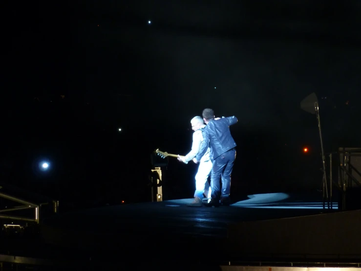 a man is walking on a stage while holding his tennis racquet