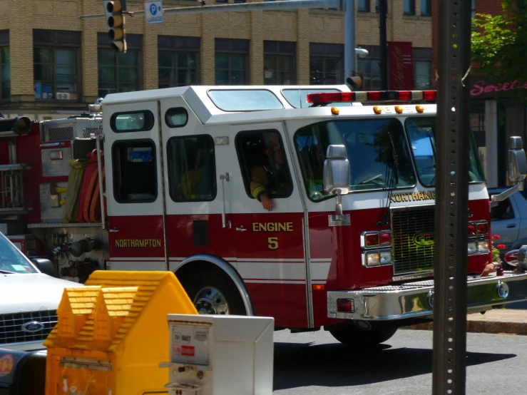 a red and white fire truck driving on a street