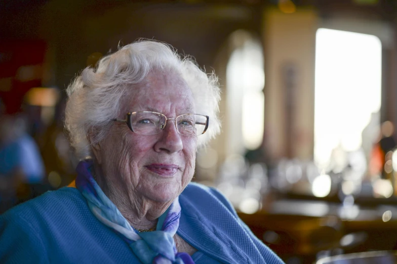 a woman wearing glasses is sitting in a bar