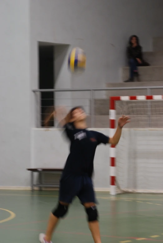 a man tossing a volleyball to a girl