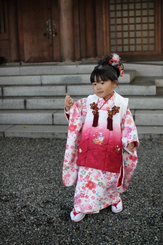 the little girl is wearing a traditional japanese dress