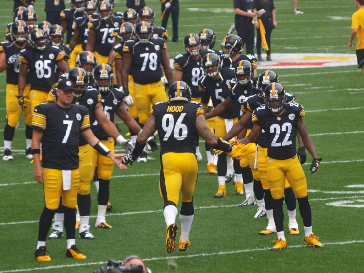 a group of pittsburgh football players holding hands