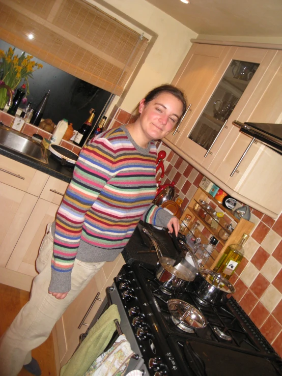 a woman standing in front of an oven with a smile on her face