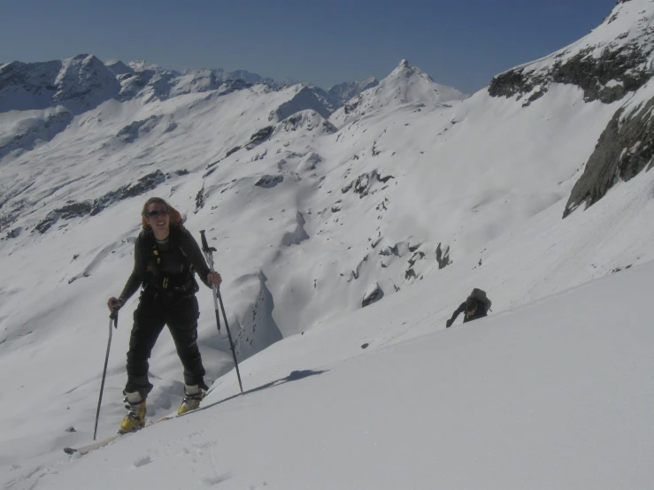 woman walking in skis on the snow while another person skiing