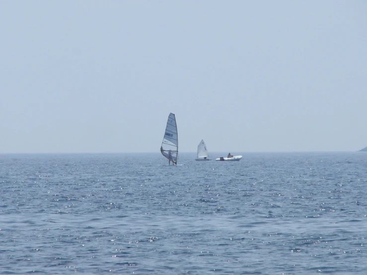 a couple of boats sailing on top of the ocean