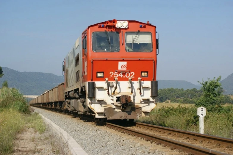 a train is riding down the tracks in the country