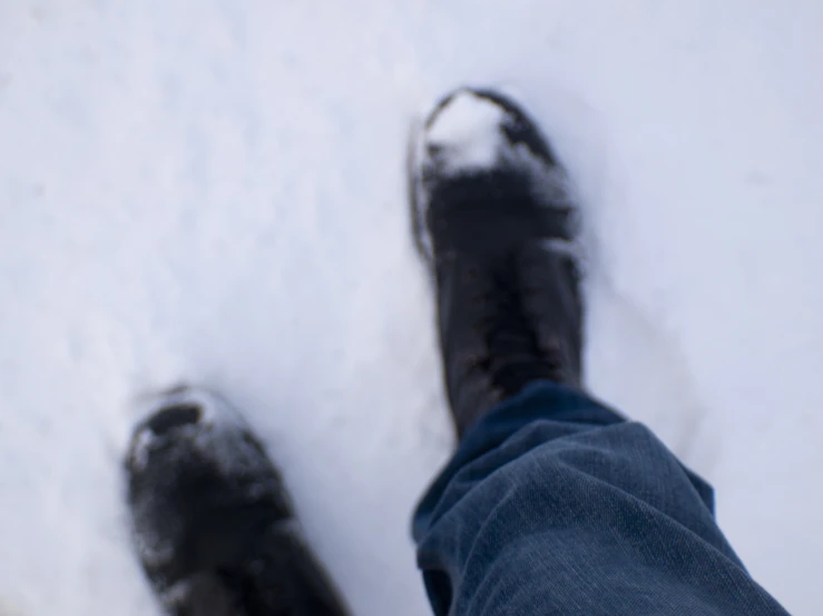 the person is standing in the snow next to a frisbee