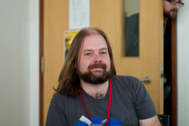 a man with long hair and beard looks at the camera