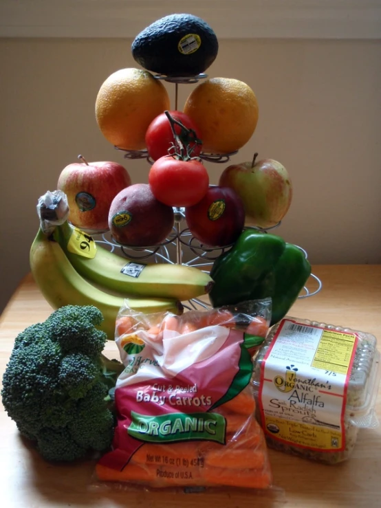 a stand with fruits, vegetables and nuts is on a table