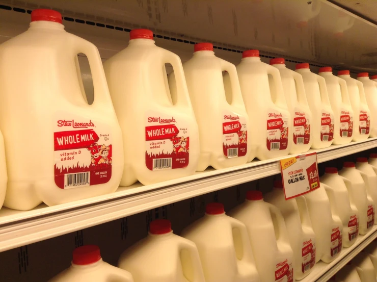 there are several rows of gallon jugs on the shelves